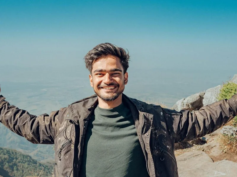 Joyful man on a mountain peak embracing nature