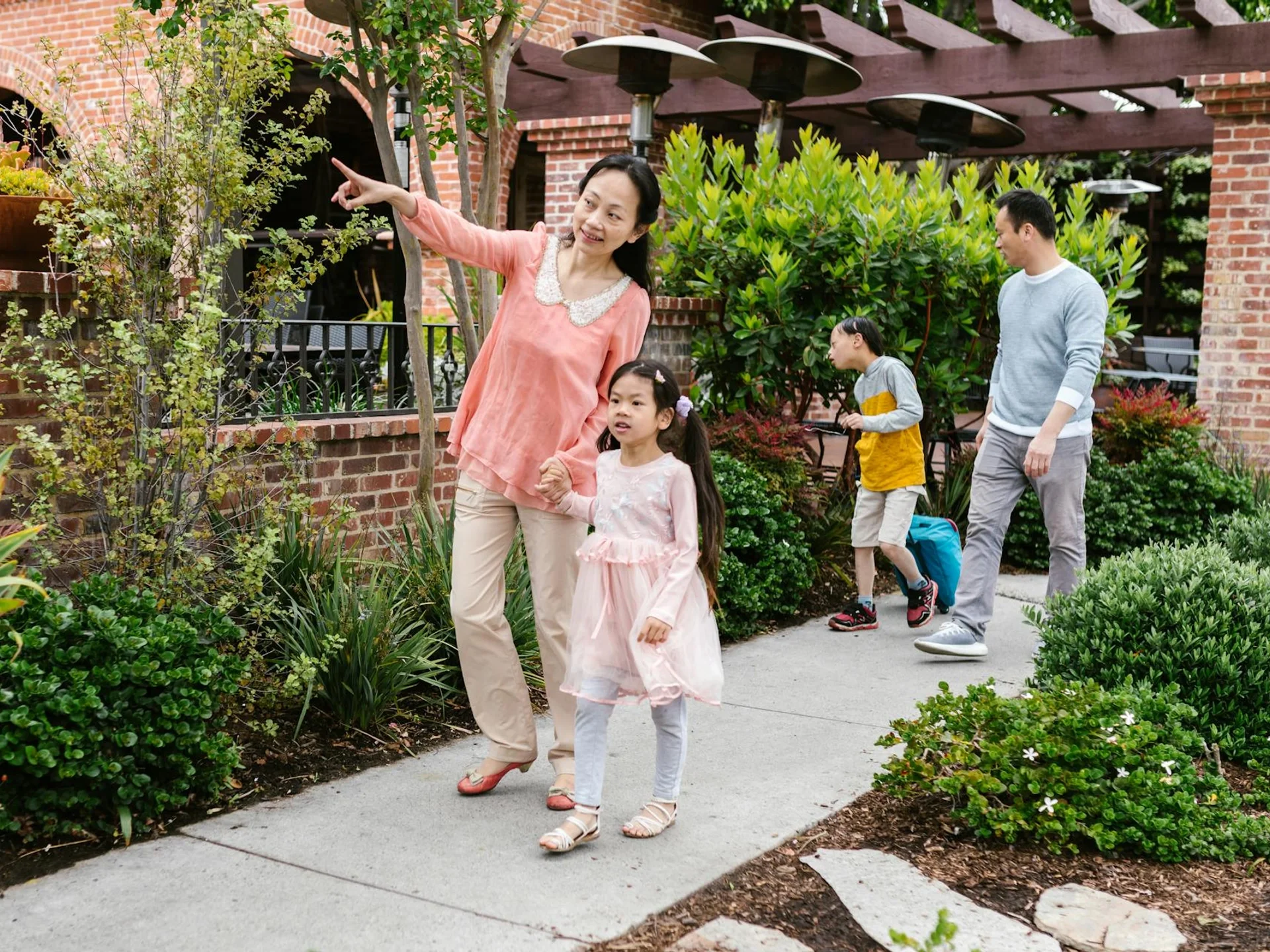 Korean family walking together through a lush garden