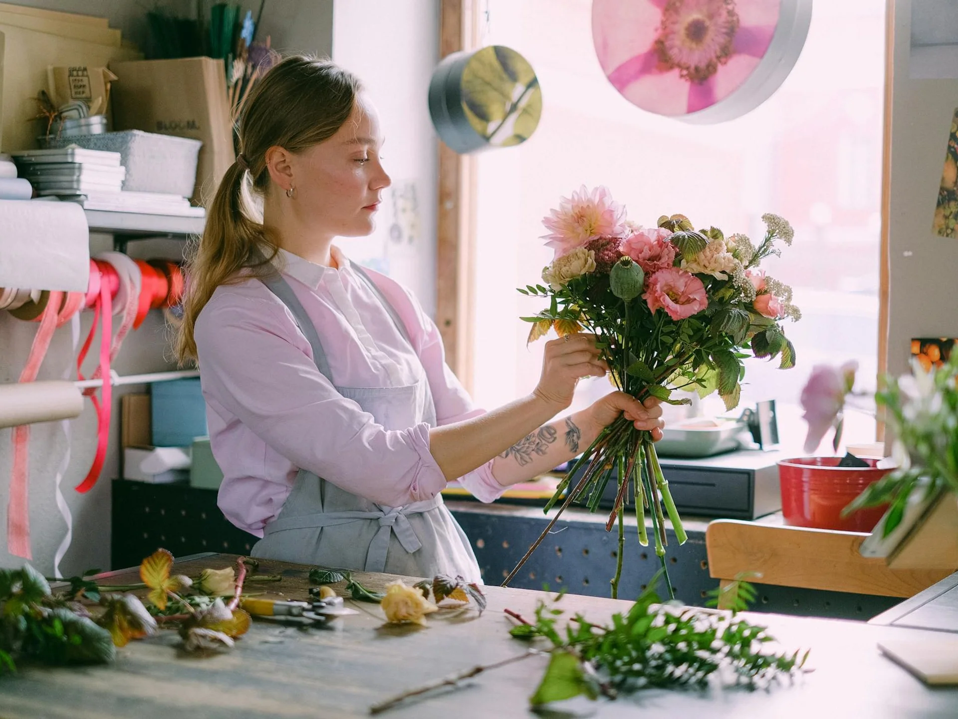 Skilled florist arranging a beautiful bouquet in a bright floral shop