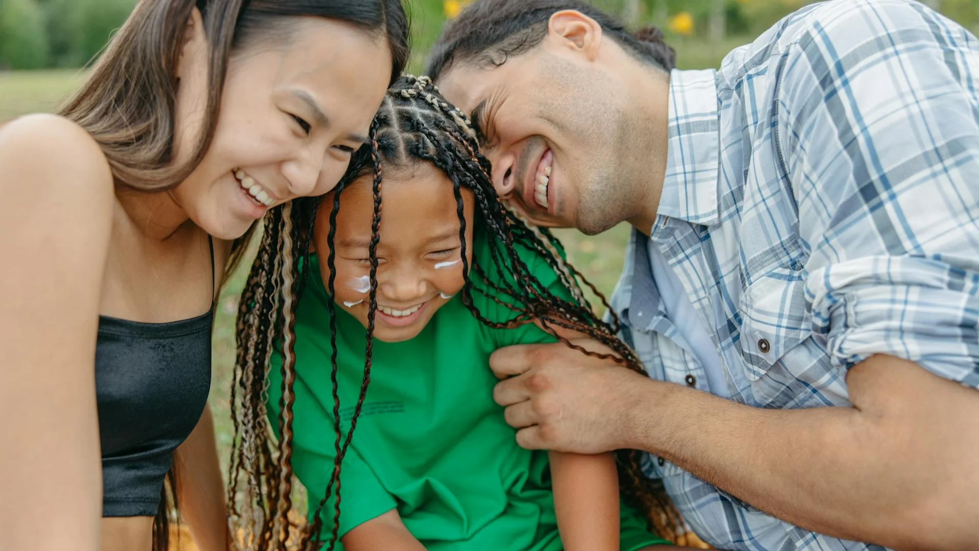 Joyful family spending time together in a sunny park, embracing happiness