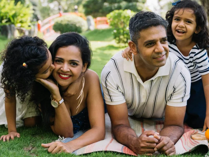 Indian family enjoying a cheerful picnic together on a lush green lawn