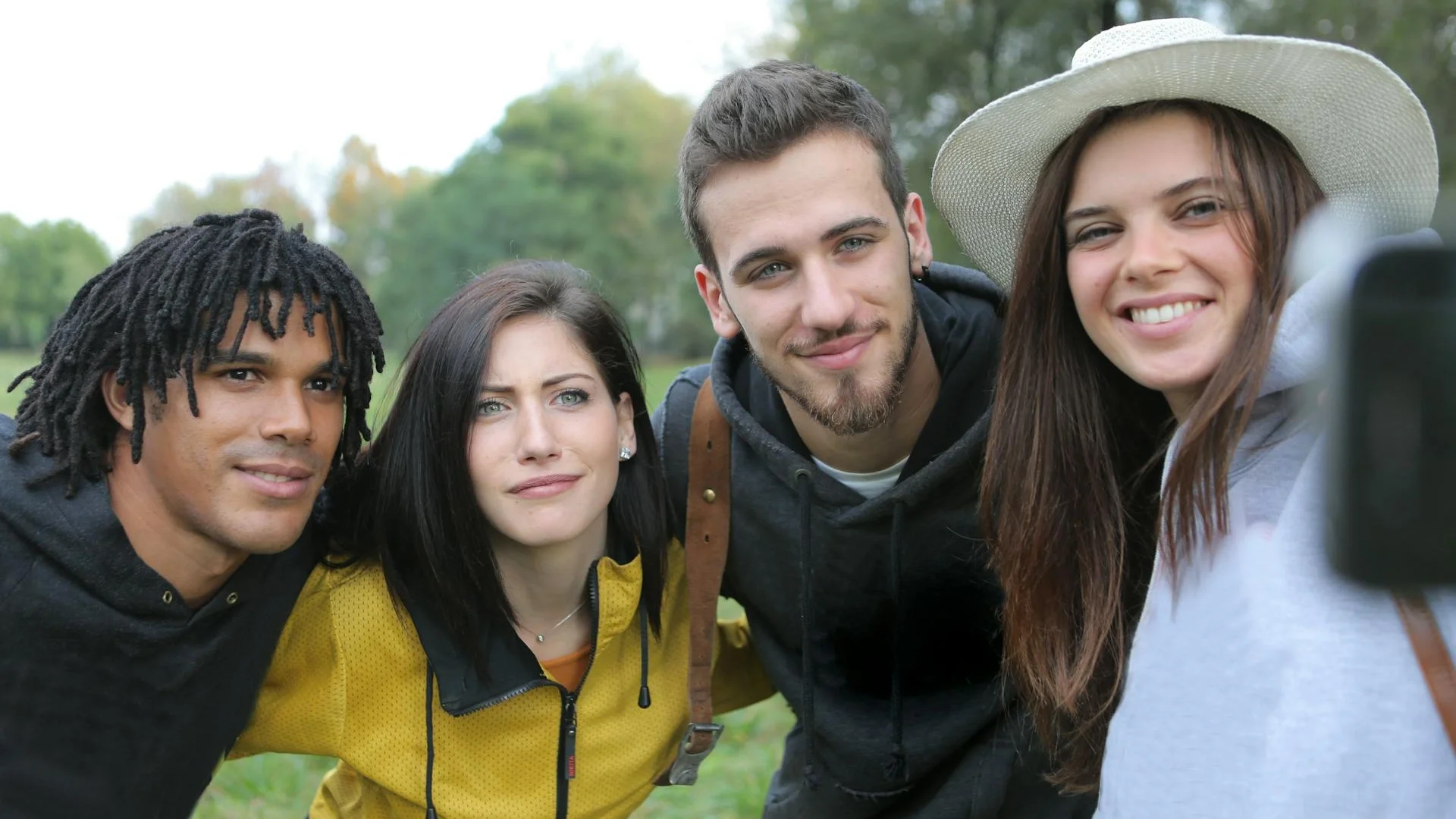 Diverse group of young friends taking a selfie together in the park