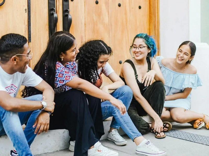 Diverse friends laughing together on sunlit steps