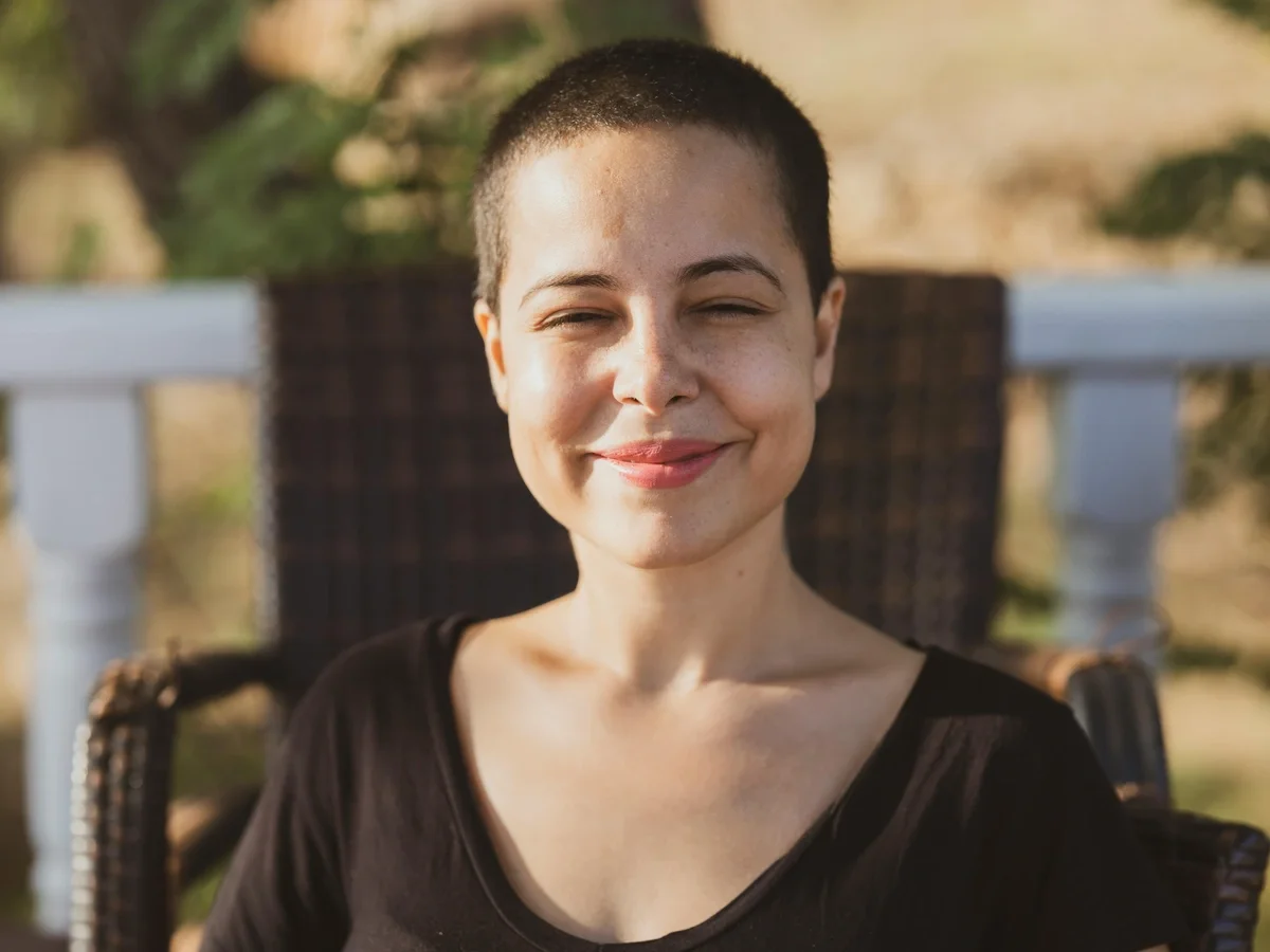 Young woman enjoying warm sunlight outdoors, radiating confidence and self-acceptance