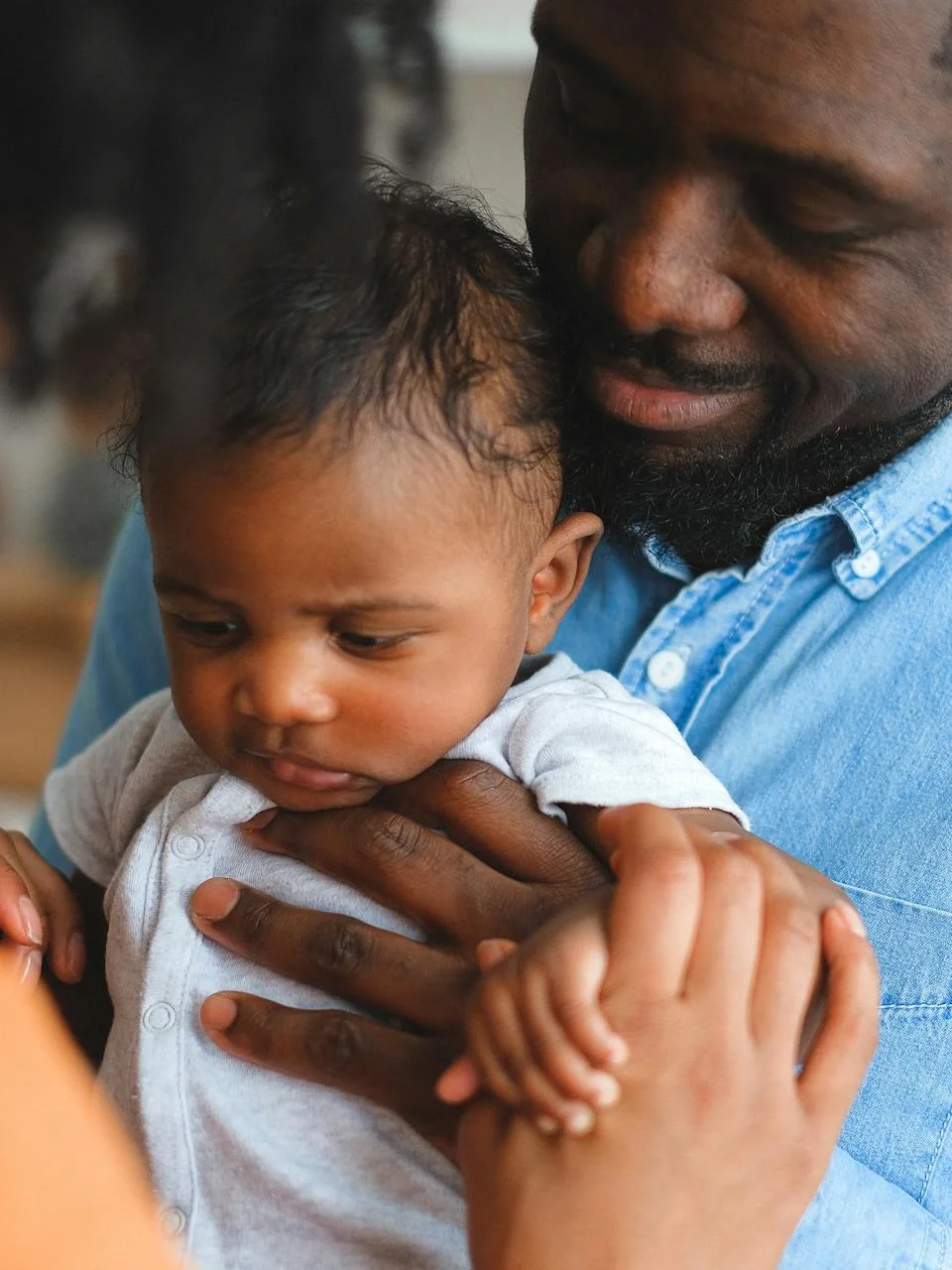 Parents sharing a loving moment while holding their baby at home