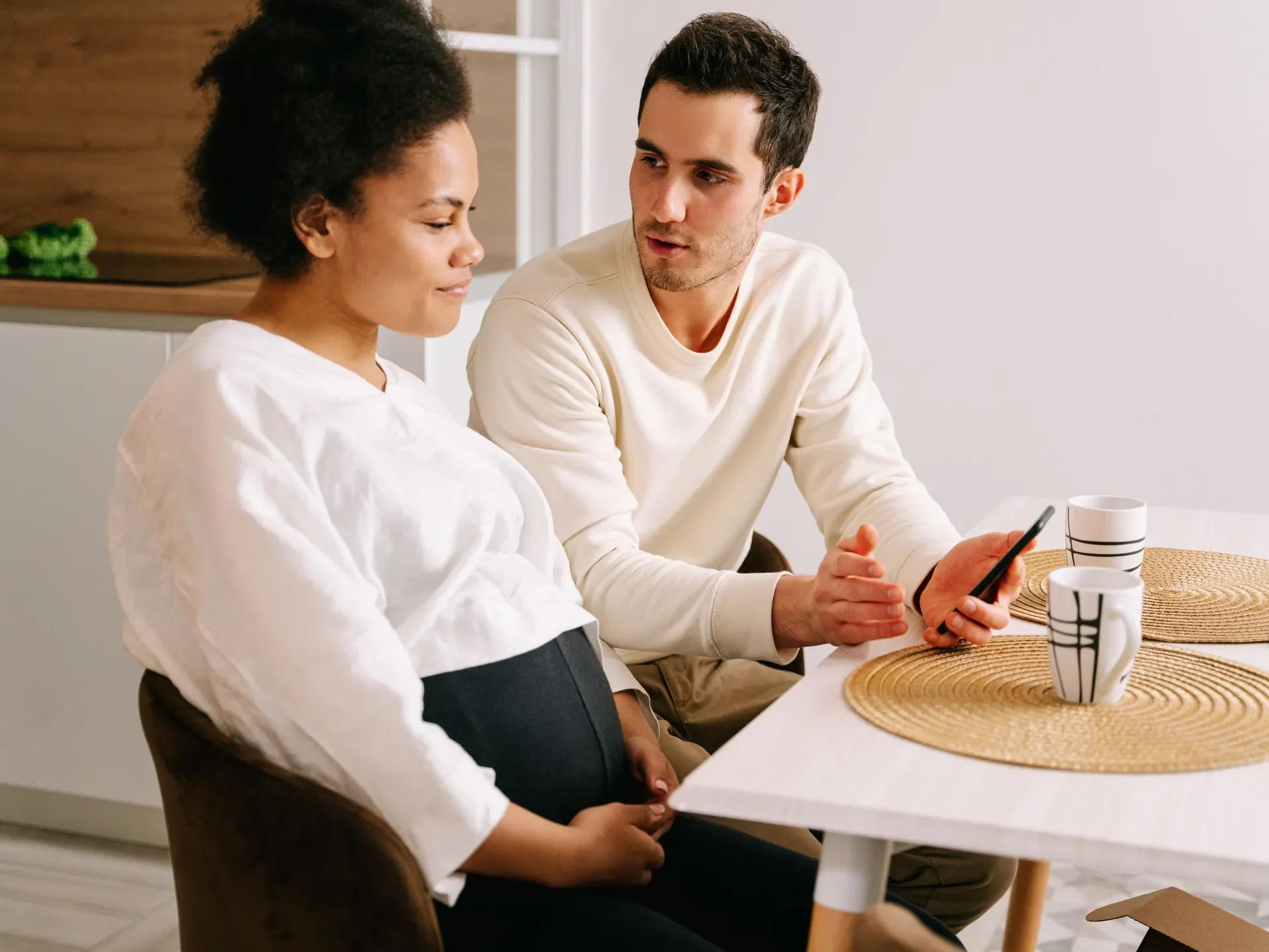 Two parents looking at a phone together, calm and engaged