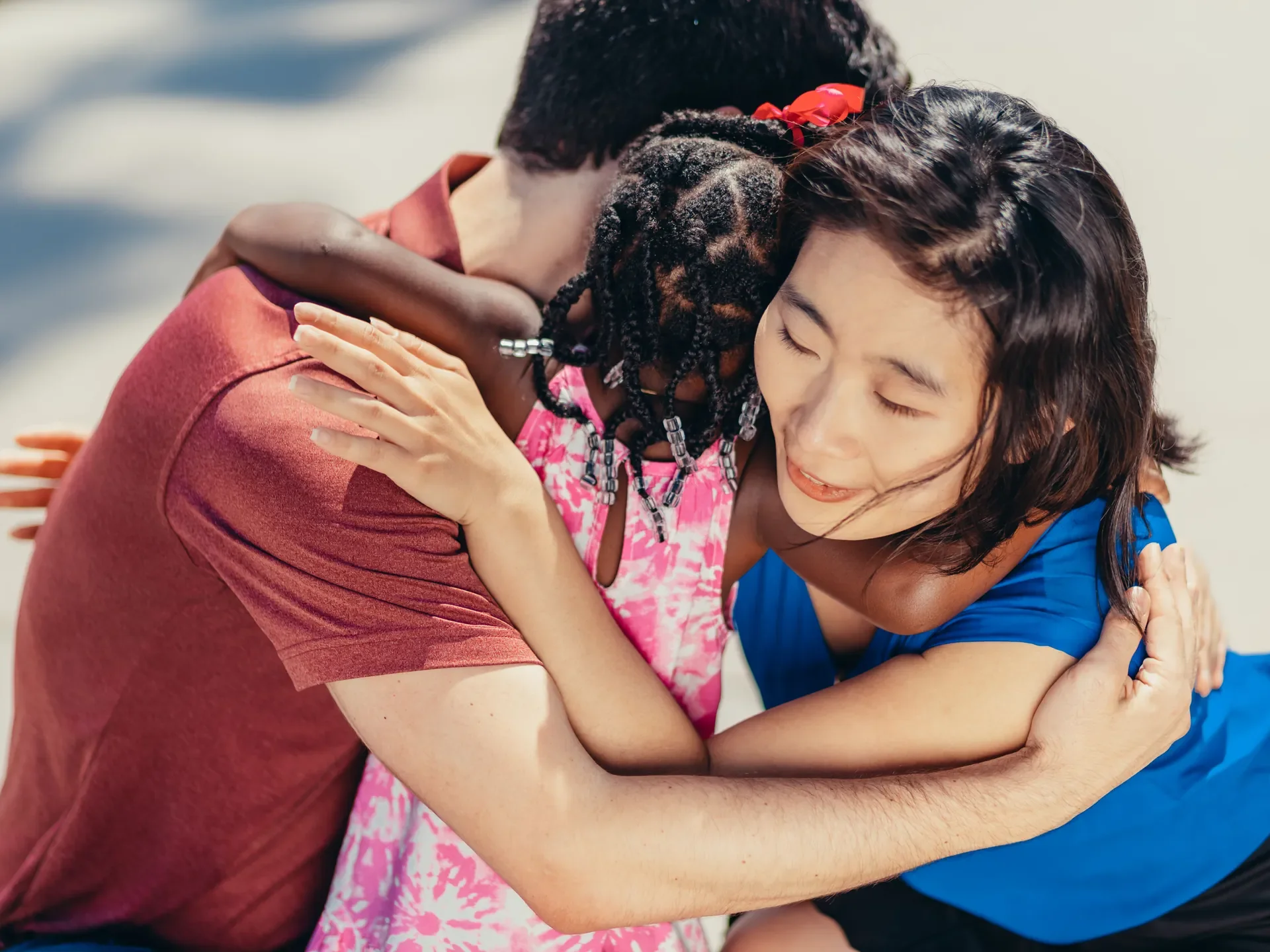 A family sharing a warm, tender group hug outdoors