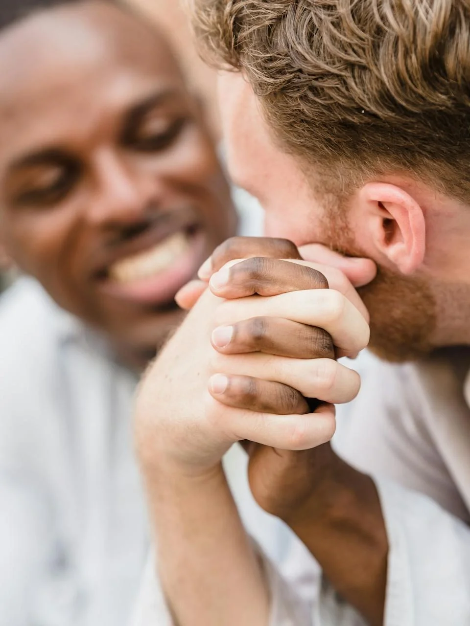 Intimate portrait of a smiling gay couple holding hands