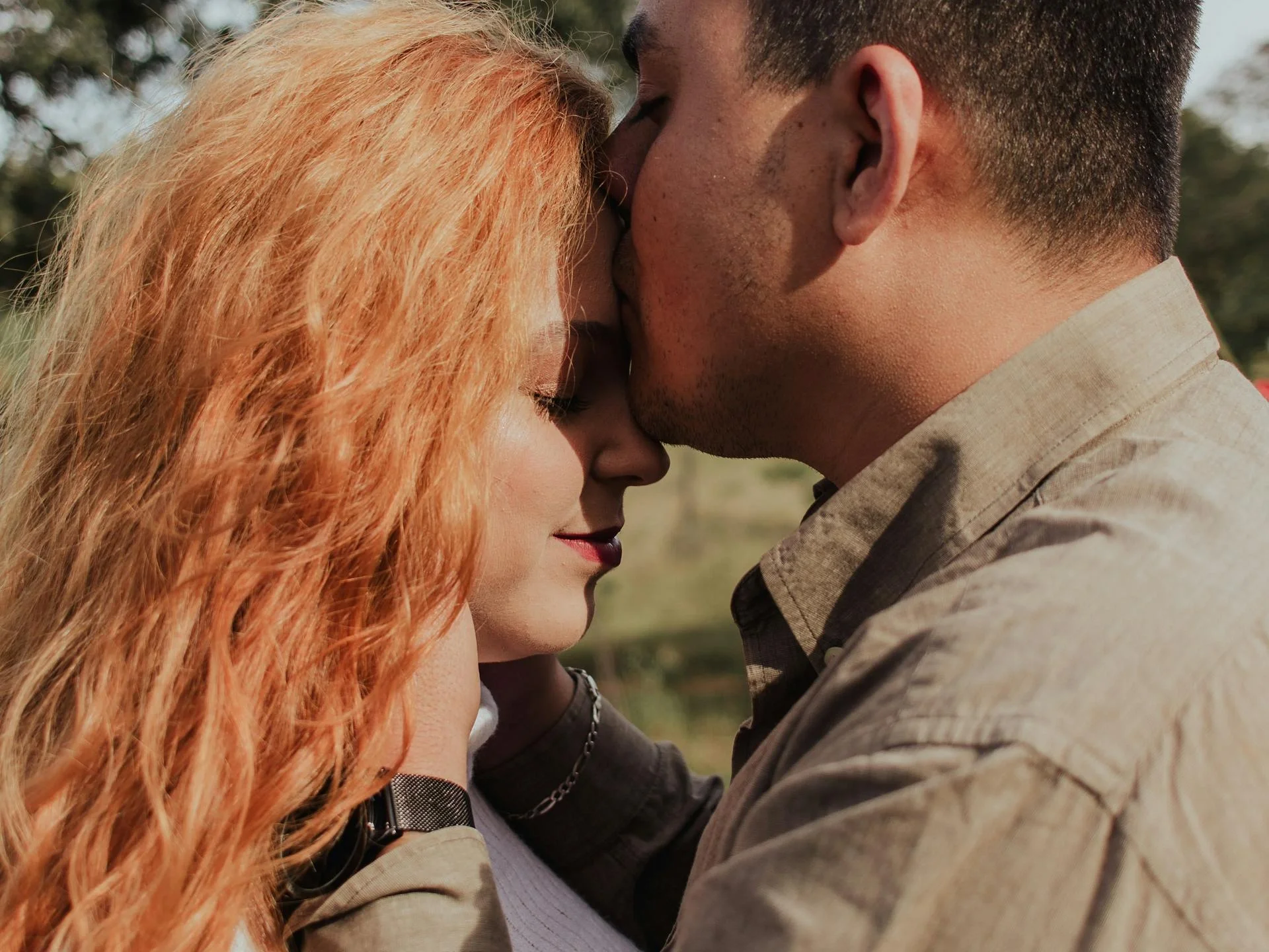 Couple sharing a tender moment outdoors, symbolizing love and affection
