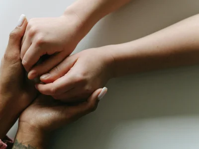 Close-up of diverse hands holding each other in a gesture of care and support