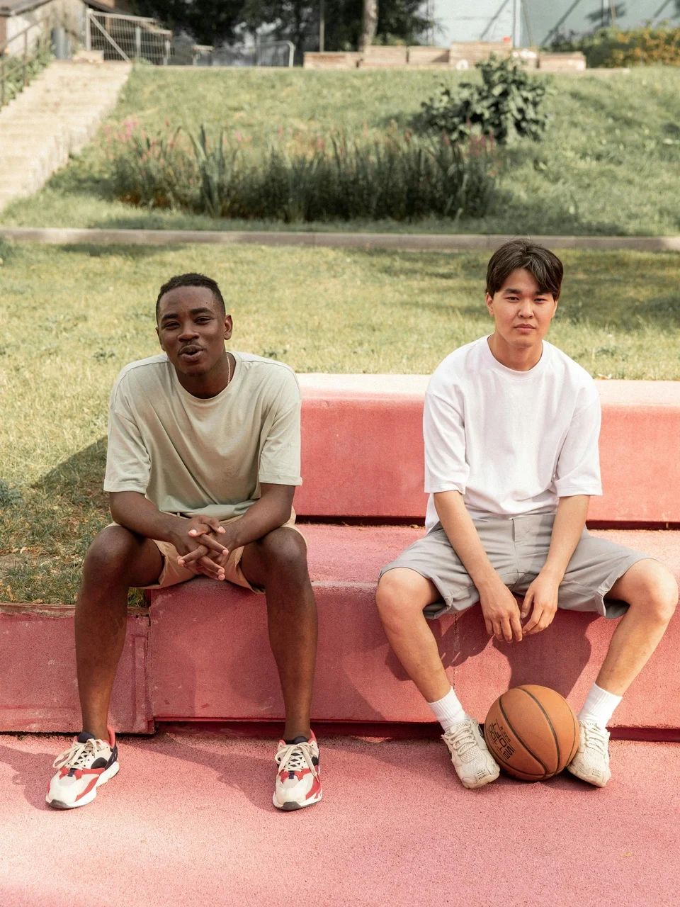 Multiracial young men relaxing on a bench after playing basketball