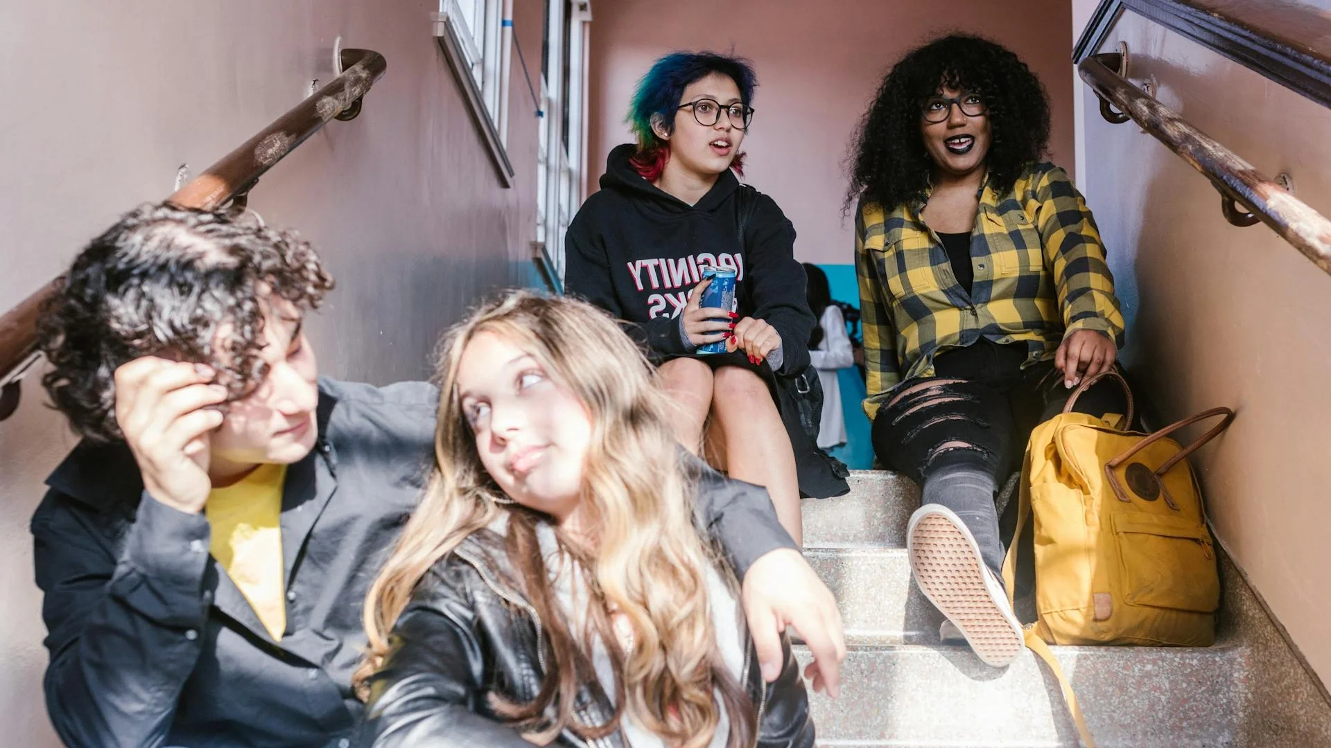 Diverse group of students sitting together on school stairs, enjoying a break